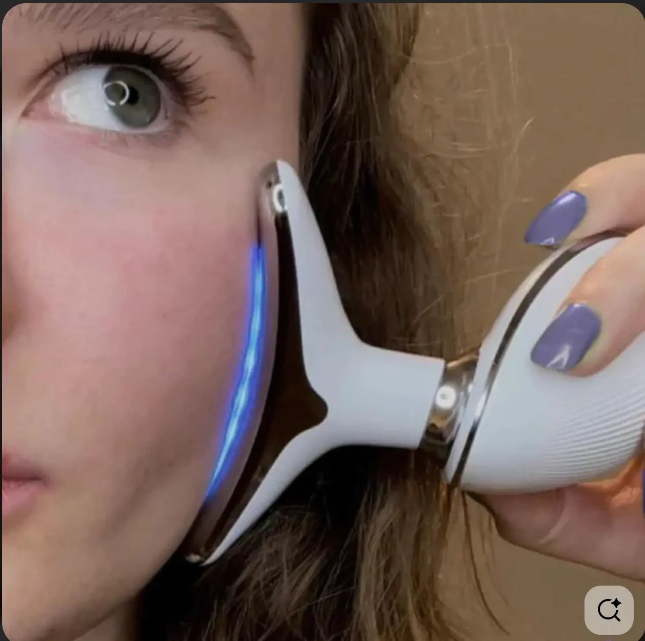 "Gros plan sur l'utilisation du sculpteur facial avec LED bleue sur la joue pour améliorer la texture de la peau et apaiser les irrégularités."