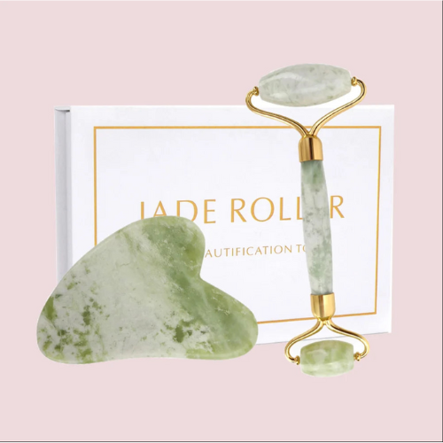Rouleau de massage facial en jade vert, avec un rouleau de jade double face et un grattoir gua sha, présenté sur une surface en marbre