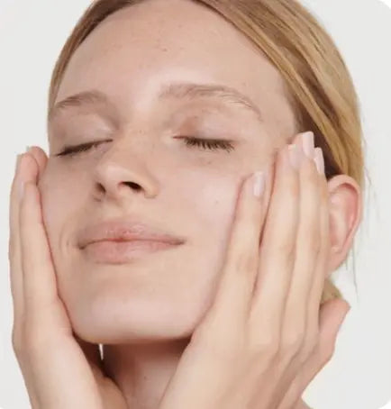 "Femme avec les yeux clos effectuant un massage liftant sur ses joues pour illustrer les bienfaits de l'appareil HIFU Lift Pro."